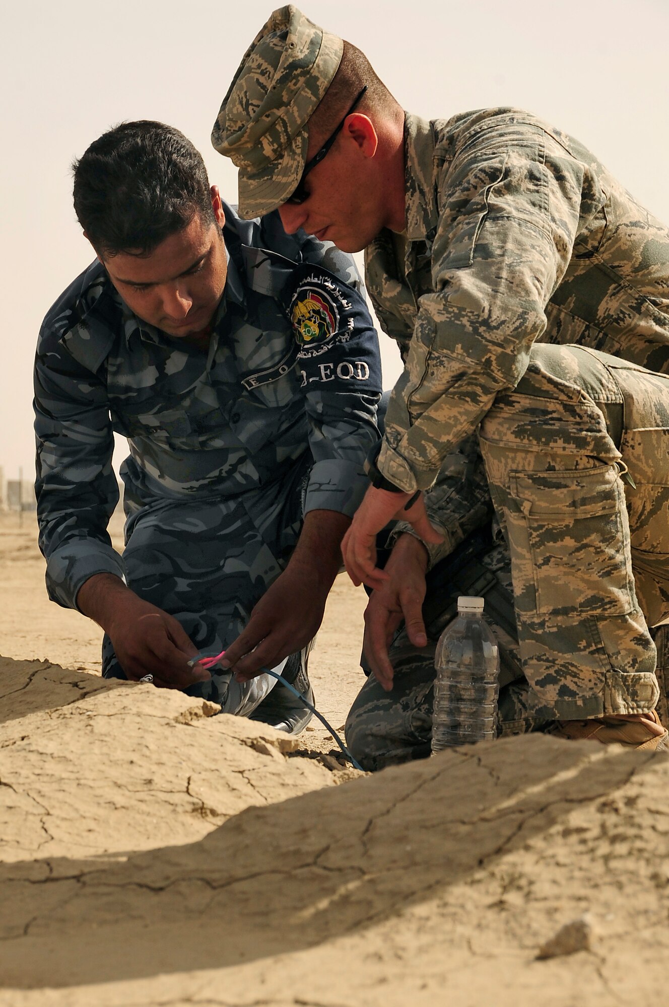 FORWARD OPERATING BASE CEDAR, Iraq -- U.S. Air Force Staff Sgt. Arthur Bigelow, explosive ordinance disposal (EOD) technician, 407th Expeditionary Civil Engineer Squadron, advises an Iraqi Police EOD technician as he inerts an improvised explosive device during a training scenario conducted by the Air Force EOD members here, Nov. 4, 2009. The training was a part of a six week course offered to the Iraqi Police to better help them understand the technicalities of EOD that would further aid in the transition of troops scheduled to withdraw from Iraq in 2011. Sergeant Bigelow is deployed here from Fairchild Air Force Base, Wash. (U.S. Air Force photo by Senior Airman Tony R. Ritter)