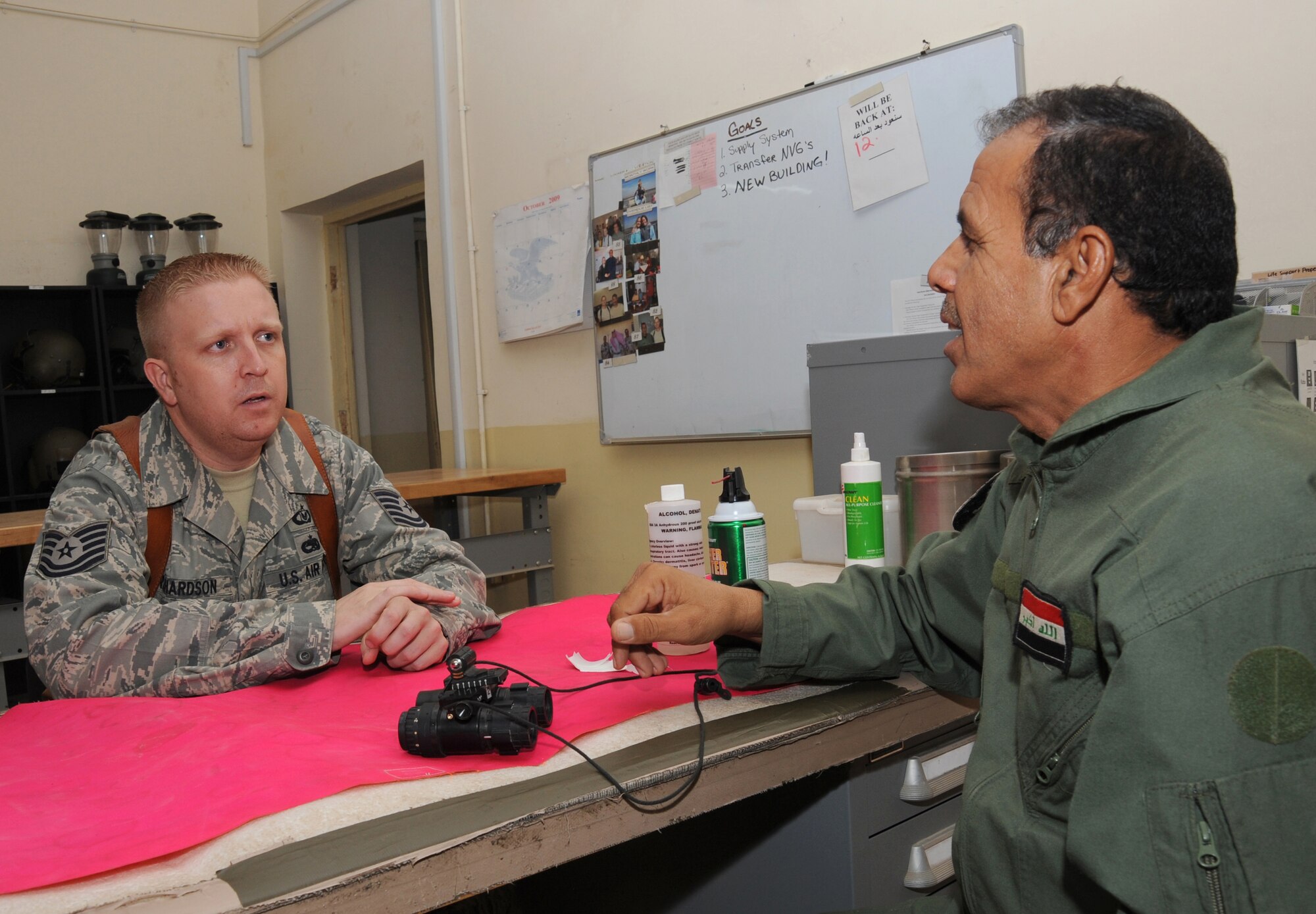 CAMP TAJI, Iraq -- Air Force Tech. Sgt. Kyle Richardson, 721st Air Expeditionary Advisory Squadron air crew flight equipment advisor, discusses night vision goggle maintenance with an Iraqi air force airman Oct. 30, 2009. Sergeant Richardson ensures the airmen properly maintain                                                                      survival vests, body armor, crash helmets and NVGs for more than 200 Iraqi helicopter air crew members. Sergeant Richardson is deployed from Shaw Air Force Base, S.C., and hails from Orleans, Ind. (U.S. Air Force photo/Tech. Sgt. Johnny L. Saldivar)
