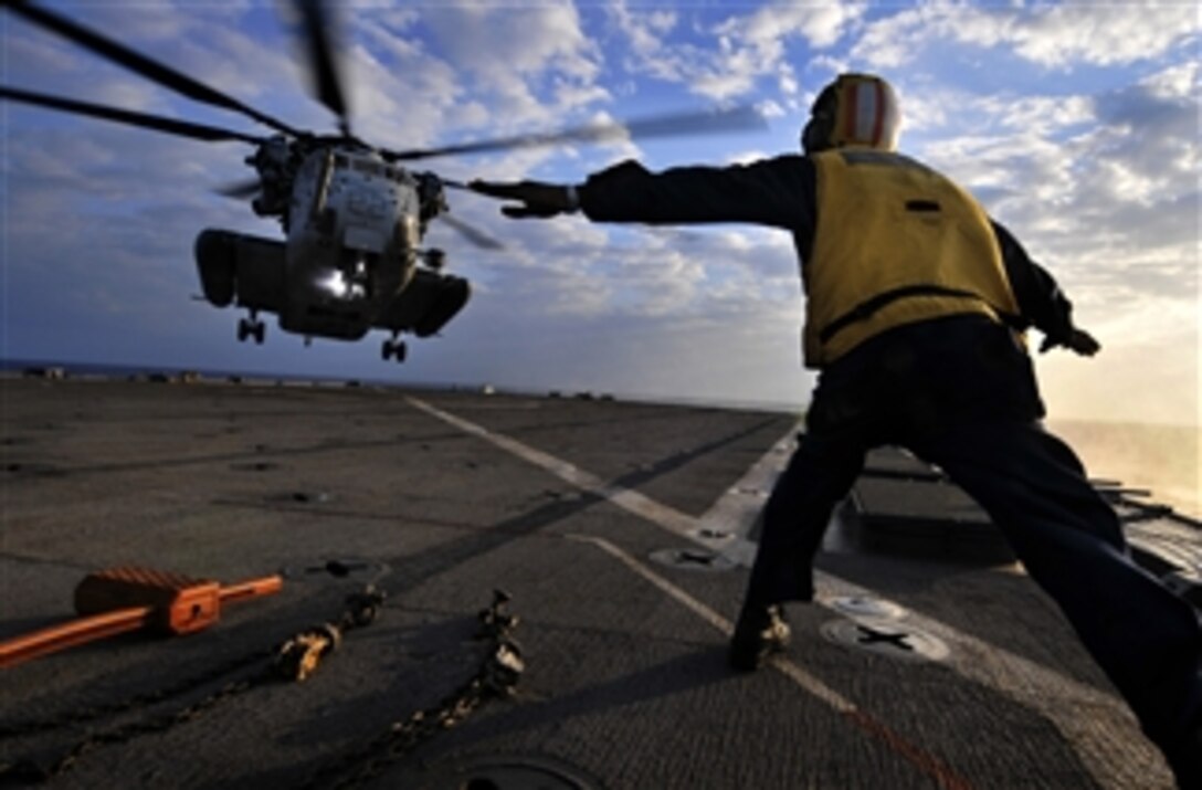 U.S. Navy Petty Officer 3rd Class Solomon Michel directs a U.S. Marine Corps CH-53E Sea Stallion helicopter as it approaches the flight deck of the amphibious dock landing ship USS Harpers Ferry (LSD 49) during touch-and-go landing qualifications in the South China Sea on Oct. 29, 2009.  The Harpers Ferry is part of the USS Denver (LPD 9) Amphibious Task Group, which is conducting fall patrol in the western Pacific Ocean with the embarked 31st Marine Expeditionary Unit.  