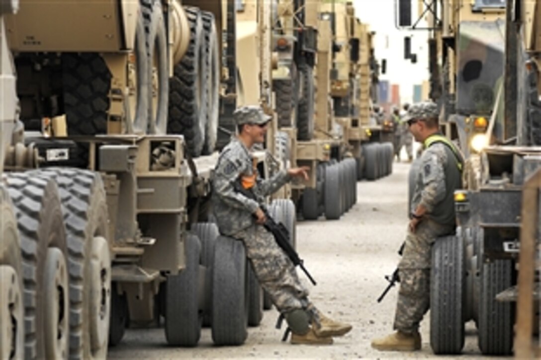 U.S. Army Pfc. Patrick Camp, left, and Spc. Thomas Garrard relax as they wait, Nov. 3, 2009, to convoy M1 Abrams tanks through the night from Contingency Operating Base Speicher to Forward Operating Base Taji, Iraq. Both are truck drivers assigned to the 3rd Infantry Division's 2025th Transportation Company, 15th Sustainment Brigade.


