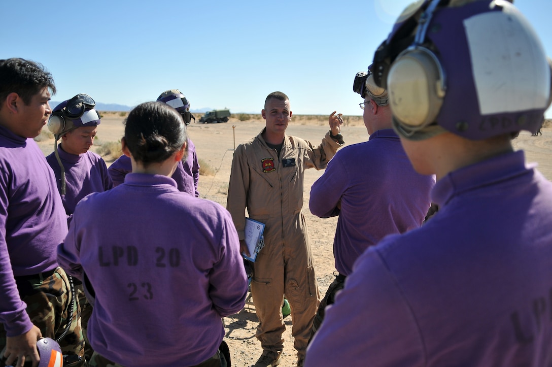 Cpl. David Brach, Marine Wing Support Squadron 371 fuel line noncommissioned officer, advises Navy aviation fuel technicians after they practiced refueling AV-8B Harriers from Air Test and Evaluation Squadron 31 at Auxiliary Airfield 2 in Yuma, Ariz., Nov. 5, 2009. The squadron and the USS Green Bay flight deck crew practiced working together at the airfield, which simulates the deck of a ship, to prepare for their upcoming testing period aboard the Green Bay. The Green Bay, commissioned January 2009, is part of the Navy’s new class of amphibious transport dock ship built specifically for helicopter operations. The squadron tested Harrier operations aboard the ship Nov. 11-15, 2009, to ensure that its design doesn’t inhibit use by Harriers in case of emergencies. Since the Green Bay is intended for helicopter use, many of its flight crew are inexperienced working with Harriers.  “A lot of our crew members are very new to the fleet and many have never worked with jets before,” said Petty Officer 1st Class Albaro Rodriguez, USS Green Bay aviation fuel technician. “This is giving them a good chance to get prepared for possible emergency situations.”