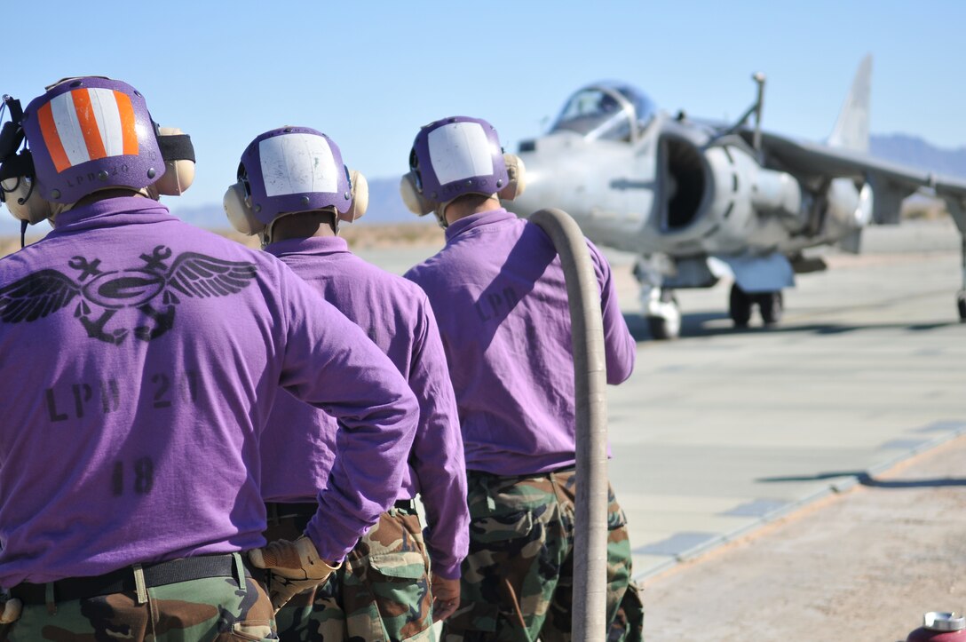 Navy aviation fuel technicians from the USS Green Bay wait to refuel an AV-8B Harrier from Air Test and Evaluation Squadron 31 as it taxis to the refueling point at Auxiliary Airfield 2 in Yuma, Ariz., Nov. 5, 2009. The squadron and the USS Green Bay flight deck crew practiced working together at the airfield, which simulates the deck of a ship, to prepare for their upcoming testing period aboard the Green Bay. The Green Bay, commissioned January 2009, is part of the Navy’s new class of amphibious transport dock ship built specifically for helicopter operations. The squadron tested Harrier operations aboard the ship Nov. 11-15, 2009, to ensure that its design doesn’t inhibit use by Harriers in case of emergencies. Since the Green Bay is intended for helicopter use, many of its flight crew are inexperienced working with Harriers.  “A lot of our crew members are very new to the fleet and many have never worked with jets before,” said Petty Officer 1st Class Albaro Rodriguez, USS Green Bay aviation fuel technician. “This is giving them a good chance to get prepared for possible emergency situations.”