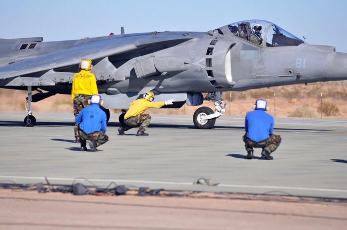 A Navy aircraft director from the USS Green Bay signals for Maj. Bill Rothermel, AV-8B Harrier test pilot with Air Test and Evaluation Squadron 31, to take off from Auxiliary Airfield 2 in Yuma, Ariz., Nov. 5, 2009. The squadron and the USS Green Bay flight deck crew practiced working together at the airfield, which simulates the deck of a ship, to prepare for their upcoming testing period aboard the Green Bay. The Green Bay, commissioned January 2009, is part of the Navy’s new class of amphibious transport dock ship built specifically for helicopter operations. The squadron tested Harrier operations aboard the ship Nov. 11-15, 2009, to ensure that its design doesn’t inhibit use by Harriers in case of emergencies. Since the Green Bay is intended for helicopter use, many of its flight crew are inexperienced working with Harriers.  “A lot of our crew members are very new to the fleet and many have never worked with jets before,” said Petty Officer 1st Class Albaro Rodriguez, USS Green Bay aviation fuel technician. “This is giving them a good chance to get prepared for possible emergency situations.”