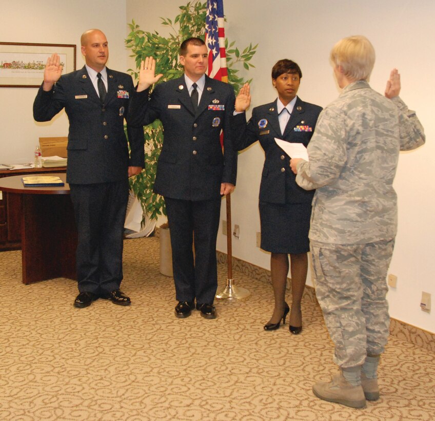 Col. Pamela LeBlanc, 452nd Mission Support Group commander, administers the Oath of Enlistment to (left to right) Tech. Sgt. Vincent Johnson, Master Sgt. Karl Perron and Master Sgt. Kamala Thigpen Oct. 30, following their promotion ceremony. The three Airmen are recruiters with the 452nd Recruiting Service. (U.S. Air Force photo by Megan Just)