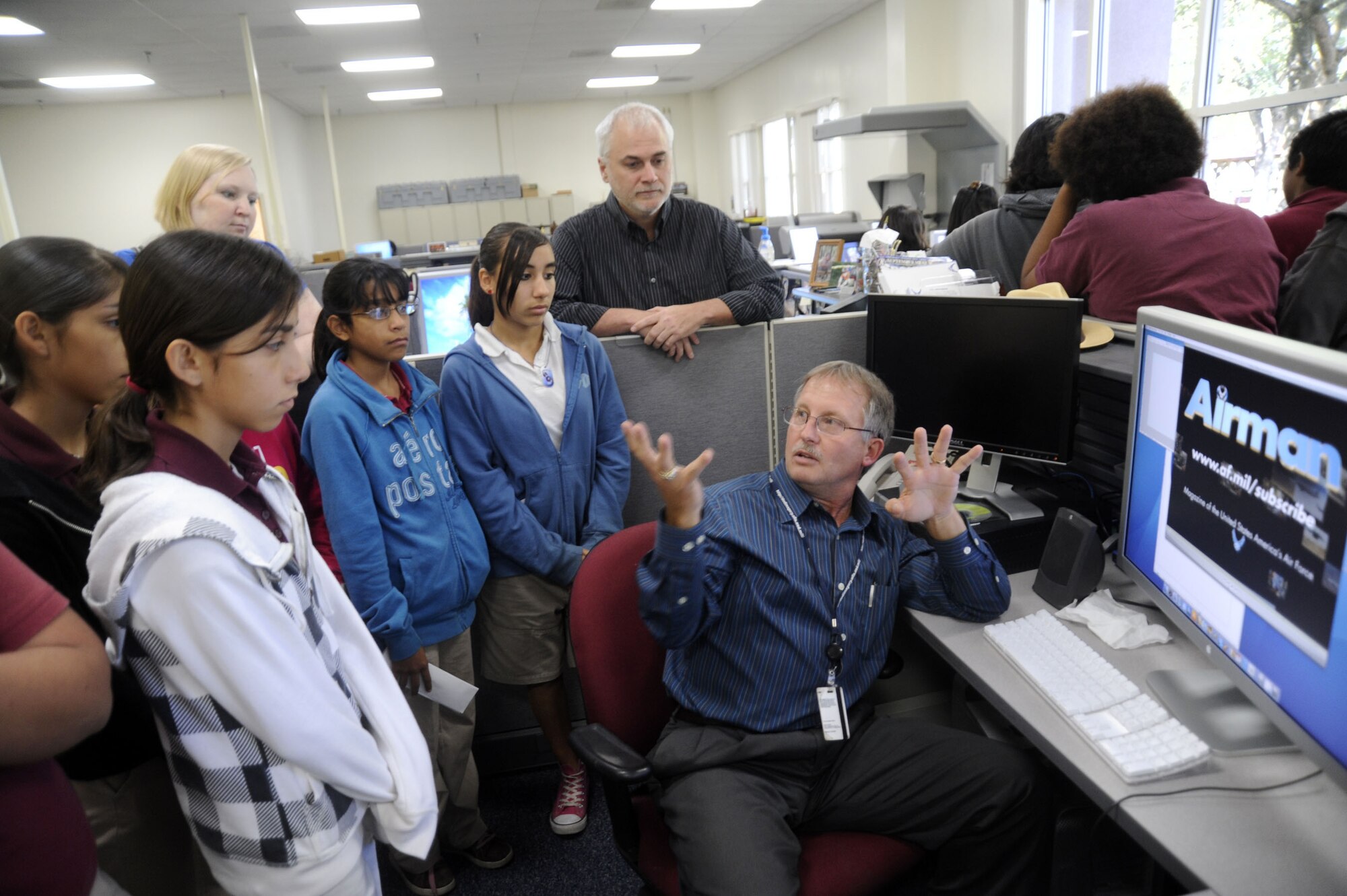 Billy Smallwood describes the design process for Airman magazine to students during a tour, Nov. 6, 2009, at the Defense Media Activity-San Antonio. Mr. Smallwood is a visual information specialist for DMA-SA and the students are from nearby Rhodes Middle School. 