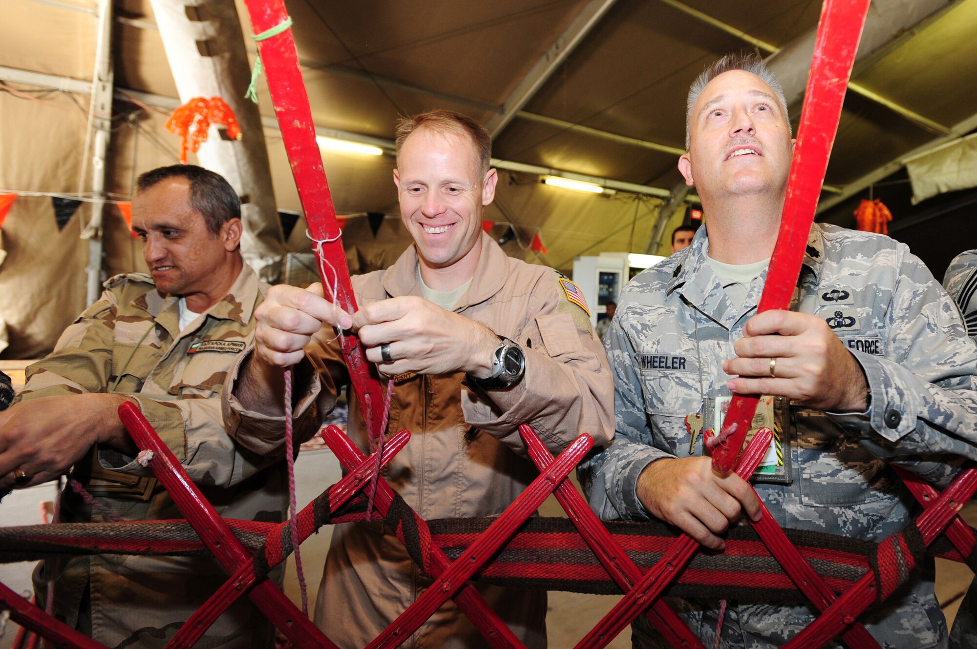 Col. Blaine Holt, 376th Air Expeditionary Wing commander, and Lt. Col. Christopher Wheeler, 376th Expeditionary Mission Support Group deputy commander, along with a coalition partner construct a traditional Kyrgyz yurt at the Transit Center at Manas, Kyrgyzstan, as part of Kyrgyz Culture Day recently. (U.S. Air Force photo/Senior Airman Steele Britton)