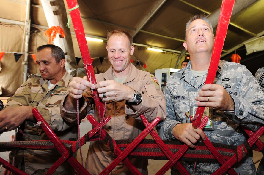 Col. Blaine Holt, 376th Air Expeditionary Wing commander, and Lt. Col. Christopher Wheeler, 376th Expeditionary Mission Support Group deputy commander, along with a coalition partner construct a traditional Kyrgyz yurt at the Transit Center at Manas, Kyrgyzstan, as part of Kyrgyz Culture Day recently. (U.S. Air Force photo/Senior Airman Steele Britton)