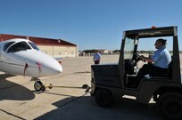 Jeffrey Johnson pushes a T-1 in position for display in preporation of Randolph AFB Airshow. Frank Womack stands by to chock plane when in position.  (U.S. Air Force photo by Steve White)