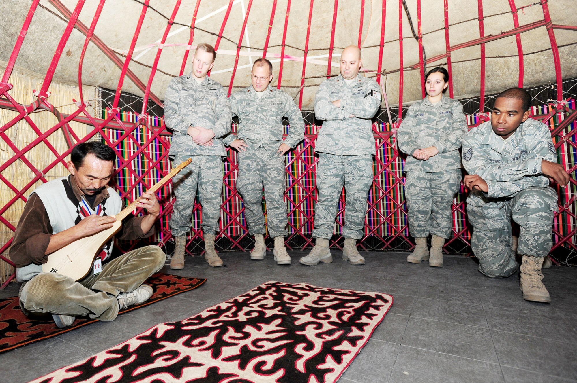 Airmen from the 376th Air Expeditionary Wing gather inside a Kyrgyz yurt to listen to music played on a komuz as part of Kyrgyz Culture day at the Transit Center at Manas, Kyrgyzstan, Oct. 24, 2009. (U.S. Air Force photo/Senior Airman Steele Britton)