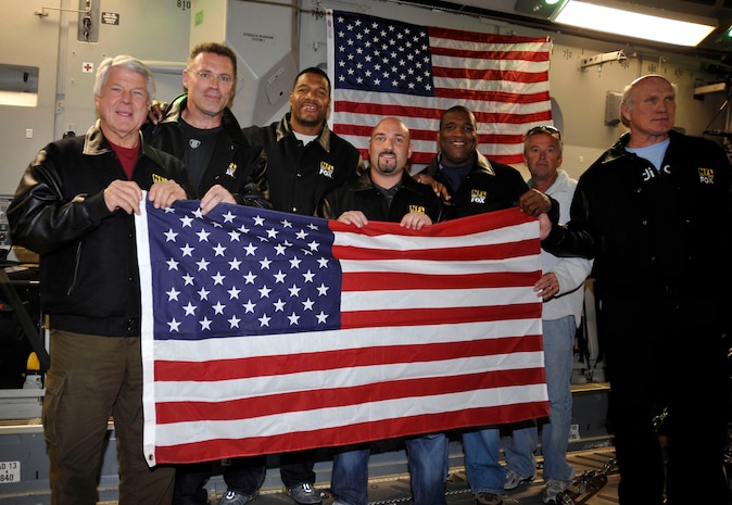 The "Fox NFL Sunday" team holds up a flag onboard a C-17 Globemaster III that was presented to them by Lt. Col Richard Williamson Nov. 5, 2009, on an airdrop mission over Afghanistan. The NFL team participated in an airdrop that supported ground troops in Afghanistan. Colonel Williamson is the 816th Expeditionary Airlift Squadron commander deployed to Southwest Asia. (U.S. Air Force photo/Staff Sgt. Angelita Lawrene)