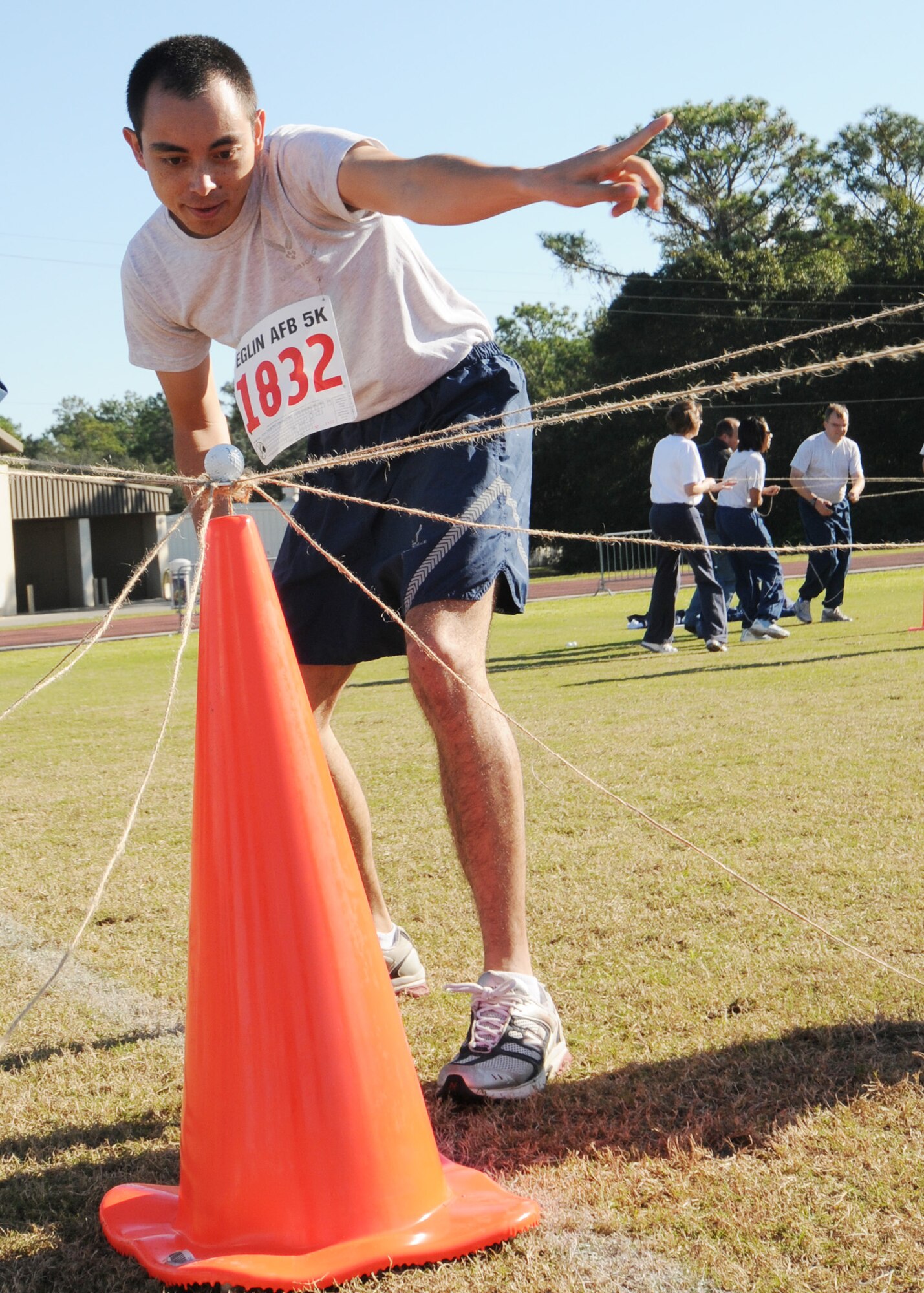 The team leader for AFOTEC Det. 2 directs his team to adjust the balance of the golf ball to secure it on top of a cone.  The exercise had team members move a golf ball with strings from one cone to another.  Teams had to work together and communicate to keep the ball from dropping.  The activity was one part of Eglin Air Force Base’s Wingman Day Nov. 5.  (Air Force photo/Samuel King Jr.)