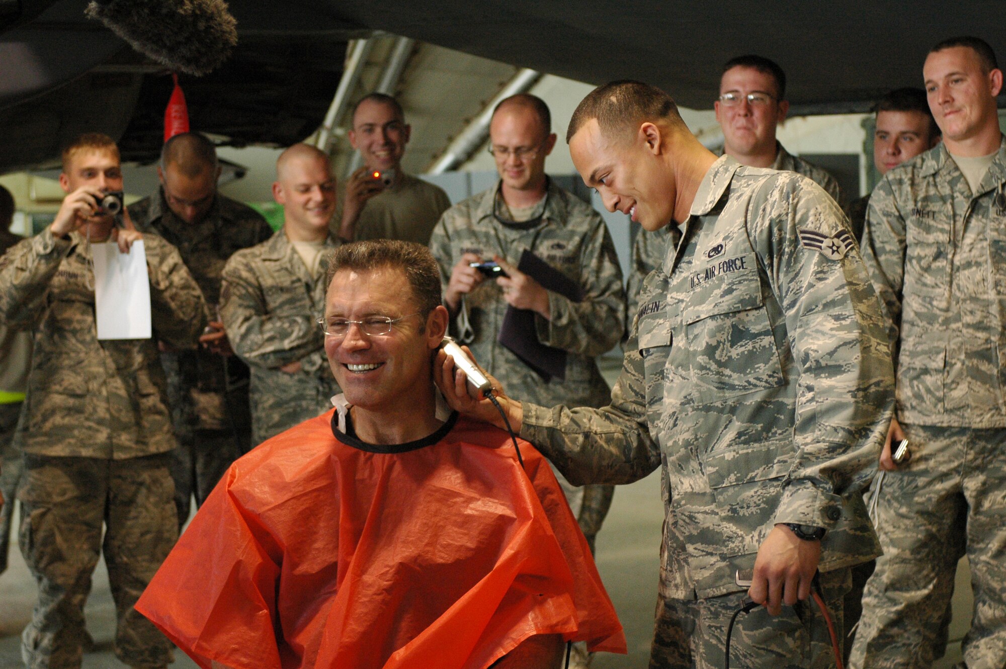 Senior Airman Nikita Canalin gives Howie Long, "Fox NFL Sunday" show host, a haircut while visiting the Airmen at Bagram Airfield, Afghanistan. The "Fox NFL Sunday" team of Curt Menefee, Terry Bradshaw, Howie Long, Michael Strahan, Jimmy Johnson and Jay Glazer is scheduled to broadcast live Nov. 8, 2009, from here. The team will do the special just three days before Veterans Day as a tribute to America's service men and women (U.S. Air Force photo/2nd Lt. Holly Hess)
