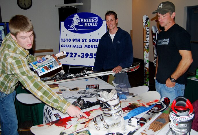Steve Groshelle and Kevin Ivers, representatives from Skiers Edge, showcase some of their snowboarding equipment to Chris Klott, one of the attendants at the Ski Expo and Dessert and Wine Fair on Oct. 29, 2009. Statewide representatives were available to offer information about resorts and lodging, and provided answers and advice about their activities and facilities. (U.S. Air Force photo/Airman 1st Class Kristina Overton)