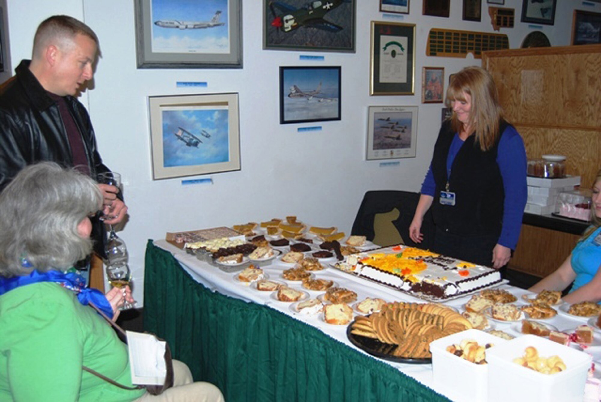 Roxanne Smith, a Sams Club salesperson, offers Master Sergeant Timothy Hezel and wife, Debrah, a sample of one of the many desserts offered at their booth at the Ski Expo and Dessert and Wine Fair Oct. 29, 2009. (U.S. Air Force photo/ Airman 1st Class Kristina Overton.)