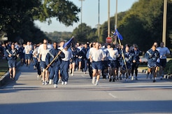 Team Charleston members run down Hill Boulevard during the Commander's 5K Run/Walk Challenge held here Nov. 6. During the fitness challenge, road guards guide traffic away from runners as they make their way from the Fitness and Sports Center. More than 530 Airmen from various base squadrons came out to participate in the challenge. (U.S. Air Force photo/James Bowman)