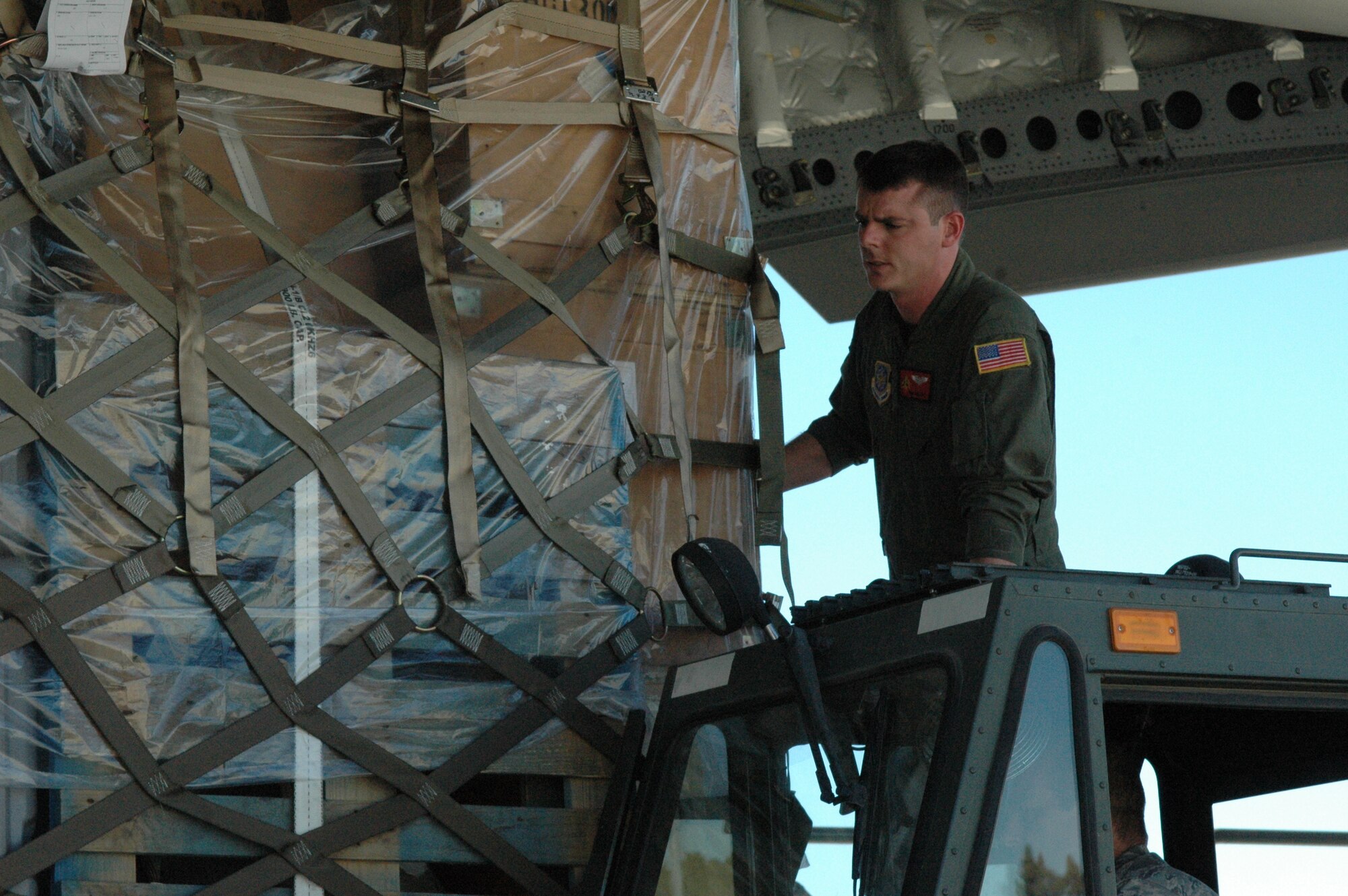 Staff Sgt. Ben Cato, C-17 loadmaster from the 21st Airlift Squadron at Travis Air Force Base, loads cargo for a mission taking a Fox Sports crew to Afghanistan for a morale show for the troops. (U.S. Air Force photo/2nd Lt. Holly Hess

