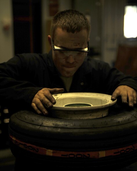 Staff Sgt. Paul Tabor, 4th Equipment Maintenance Squadron inspection team member, installs half of a wheel assembly into a nose landing gear tire of an F-15E Strike Eagle on Seymour Johnson Air Force Base N.C., Nov. 5, 2009. The wheel and tire shop rebuilds unserviceable tires so there is a local stock of replacement wheels. (U.S. Air Force photo/Senior Airman Ciara Wymbs)