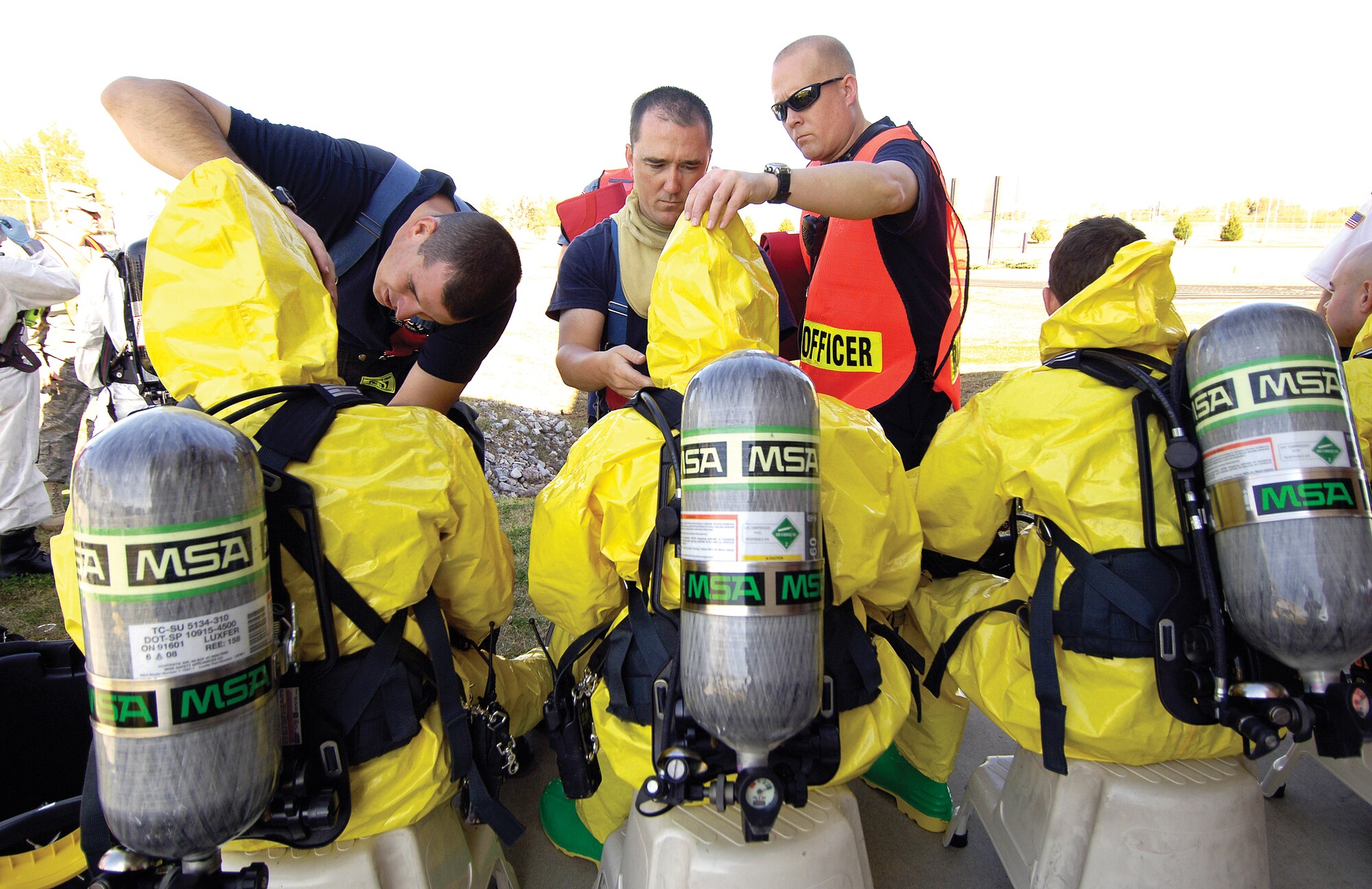 Tinker Fire Department Lieutenants Travis Willoughby, Jerol Williams and Billy Newton, from left, prepare firefighters in hazardous material protective suits to enter the scene of an Operational Readiness Inspection Major Accident Response Event exercise Nov. 3. The event followed two days of deployment processing. Wednesday, Thursday and today, inspectors are focusing on Airmen’s Ability to Survive and Operate at the Glenwood Training Area. (Air Force photo by Margo Wright )