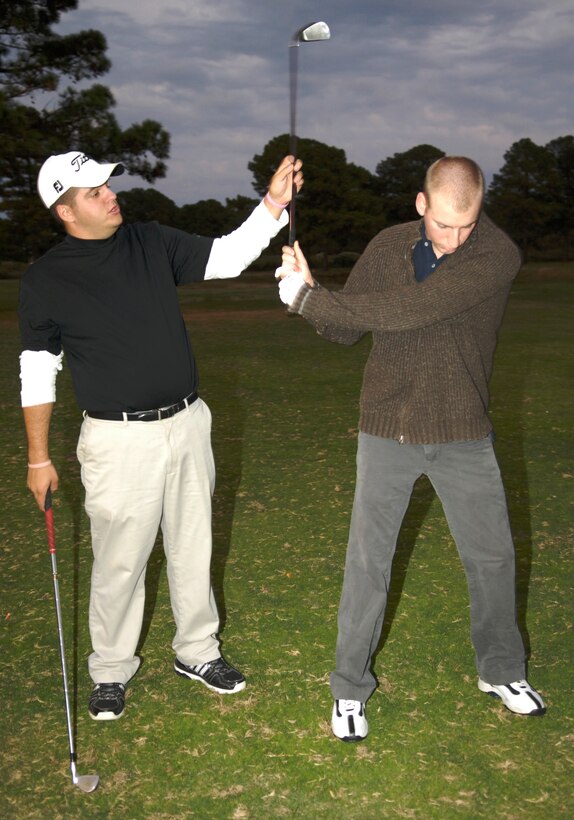 LANGLEY AIR FORCE BASE, Va. -- Josh Faldowski, Eaglewood Golf Course Golf Operations manager, teaches Airman 1st Class Steven Hall, 30th Intelligence Squadron, how to properly swing a club during a Single Airmen Golf Clinic here Nov. 4. The clinic is one of many events being held during The Military Family Week, Nov. 1-Nov. 7. (U.S. Air Force photo by Staff Sgt. Jeff Nevison)