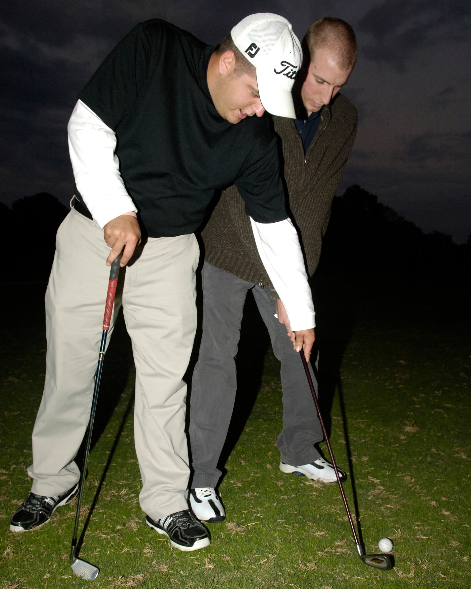 LANGLEY AIR FORCE BASE, Va. -- Josh Faldowski, Eaglewood golf course Golf Operations manager, teaches Airman 1st Class Steven Hall, 30th Intelligence Squadron, how to stand, hold a golf club and aim at a target properly during a Single Airmen Golf Clinic here Nov. 4. The clinic is one of many events being held during The Military Family Week, Nov. 1-Nov. 7. (U.S. Air Force photo by Staff Sgt. Jeff Nevison)