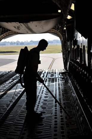 Staff Sgt. Jeffery Sausman  performs foreign object damage cleaning and inspection by vacuuming loose debris from the floor of a C-17 here Nov. 4. Foreign object damage caused by debris is prevented through regular aircraft inspections. Sergeant Sausman is a crew chief with the 315th Aircraft Maintenance Squadron. (U.S. Air Force photo/James Bowman) 