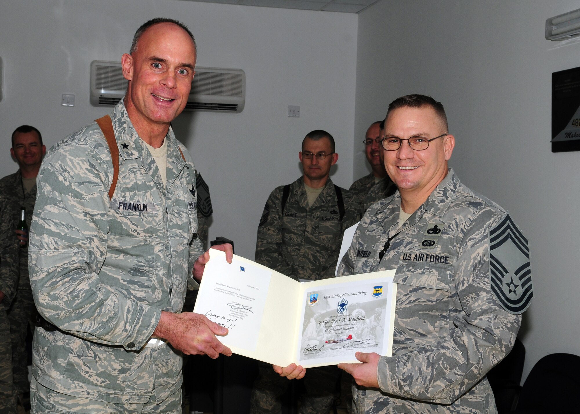 JOINT BASE BALAD, Iraq -- Brig. General Craig Franklin, 332nd Air Expeditionary Wing commander, congratulates Senior Master Sgt. Brock Mayfield with the Viper Aircraft Maintenance Unit on his promotion selection to Chief Master Sgt. Nov. 5. JBB welcomed two selectees to the rank of Chief.  Sergeant Mayfield is deployed from Spangdahlem Air Base, Germany. (U.S. Air Force photo/Staff Sgt. Heather M. Norris)