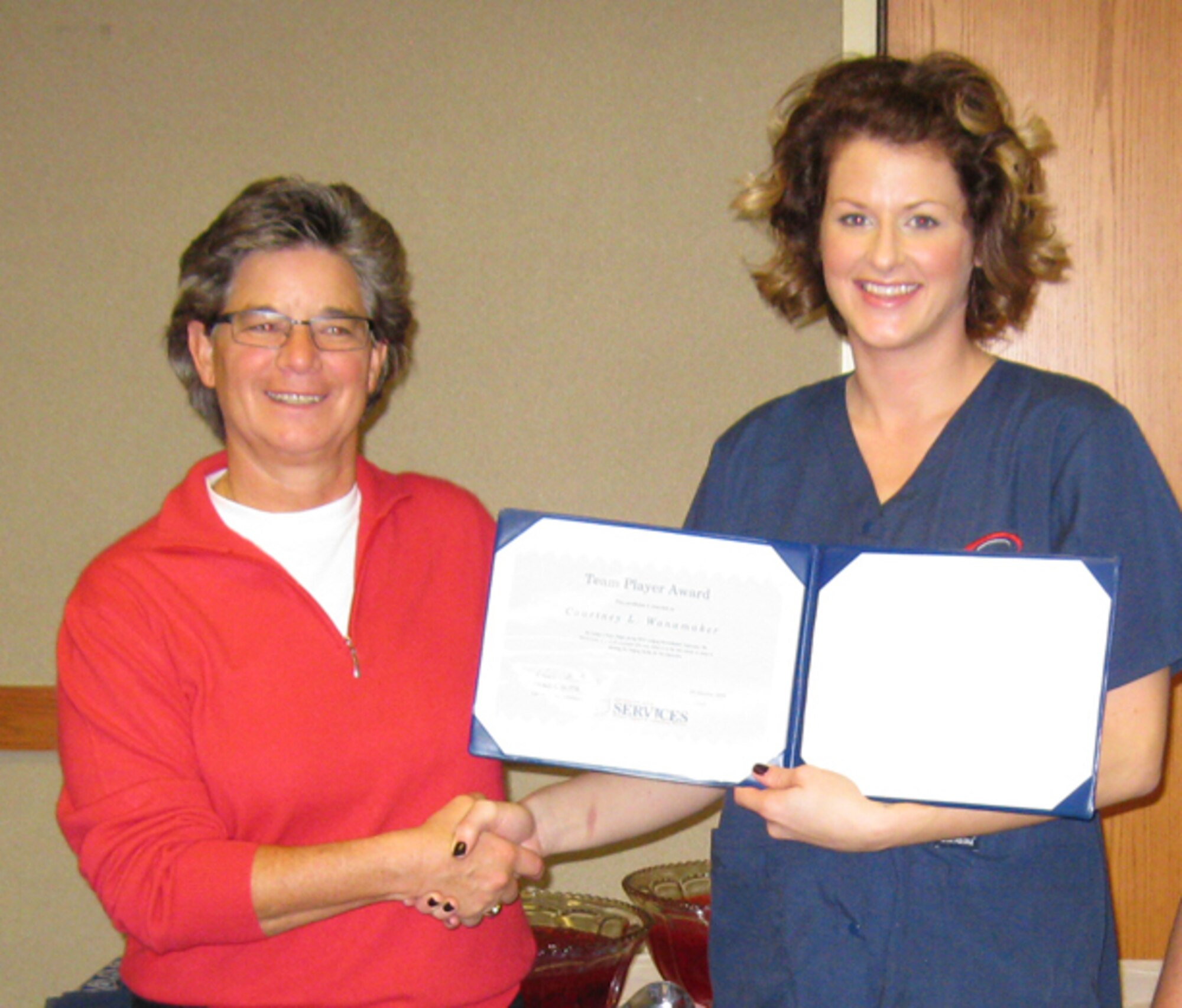GRISSOM AIR RESERVE BASE, Ind., -- Vickie Butte (left), director of services, presents a team player award to Courtney Wanamaker during a recent recognition ceremony.  Ten members of the Services Flight were presented with awards that ranged from stellar performer to team leader. (U.S. Air Force photo/Tech. Sgt. Douglas Hays)                               