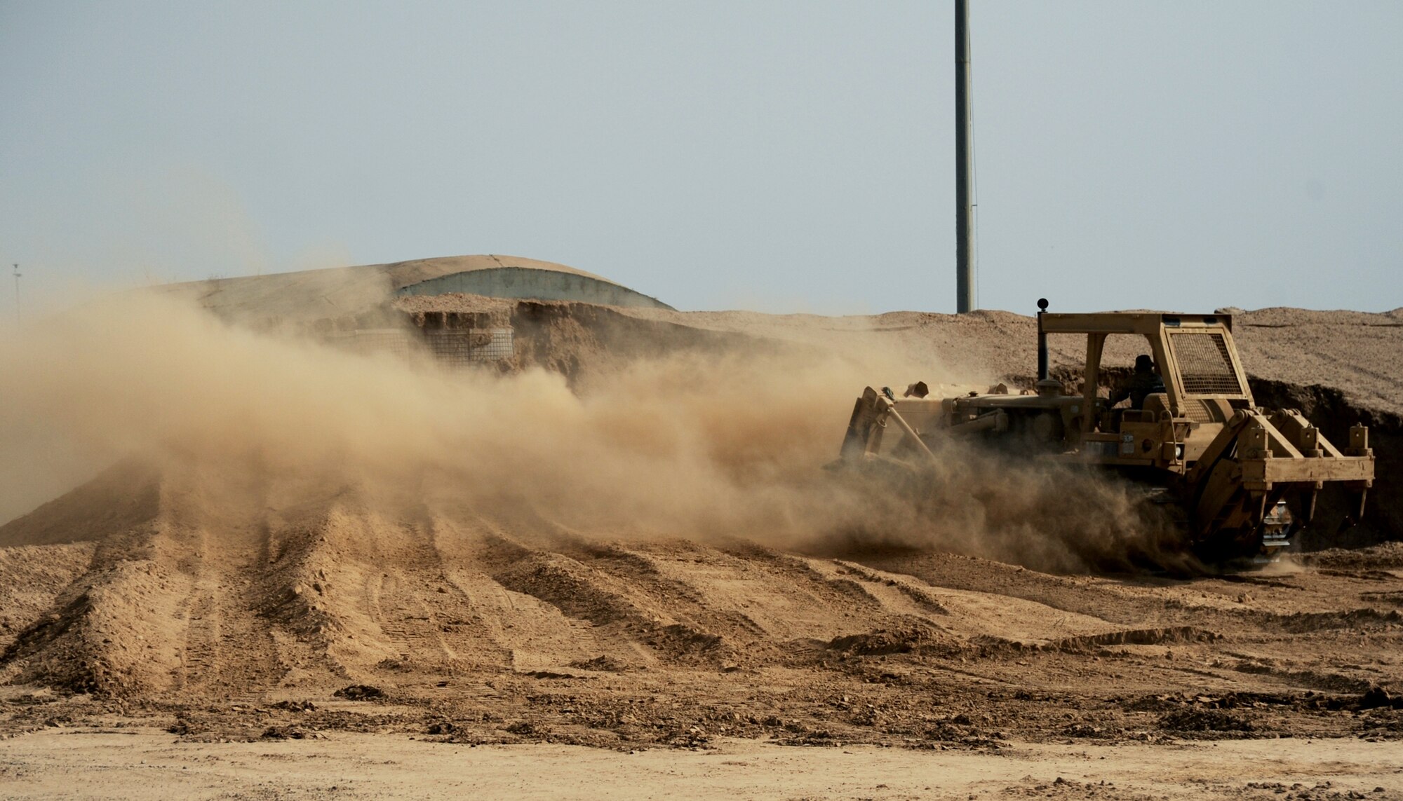 JOINT BASE BALAD, Iraq -- An Airman of the 732nd Expeditionary Civil Engineer Squadron stockpiles dirt with a bulldozer during construction of a new container repair yard Nov. 2, 2009. By using containers repaired here instead of purchasing new ones, the projected savings total more than $100 million as military assets withdraw from Iraq. (U.S. Air Force photo/Senior Airman Christopher Hubenthal)