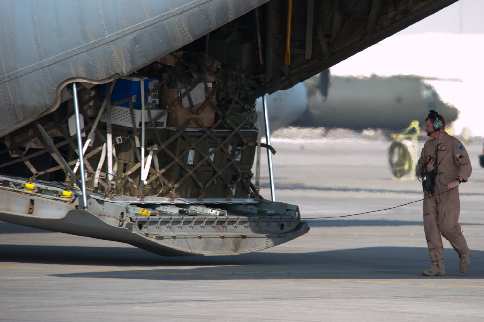 Royal Australian Air Force Sergeant Grahame Barling, No. 37 Squadron loadmaster, observes the engines on a C-130J prior to departure, Nov. 5, 2009, in Southwest Asia. The No. 37 Squadron is moving its operations to another location in Southwest Asia after six years of operating out of this undisclosed location in SWA. Sergeant Barling is deployed from RAAF Base Richmond, New South Wales, Australia in support of Operation Slipper, Australian's military contribution to international campaigns against terrorism. (U.S. Air Force photo/Staff Sgt. Robert Barney)