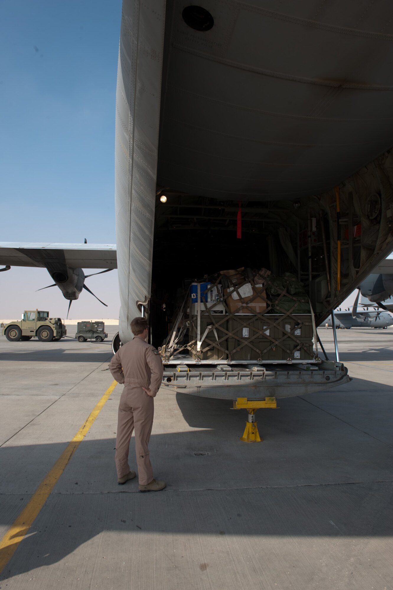 Royal Australian Air Force Flying Officer Angus Allan, No. 37 Squadron pilot, surveys the last load of cargo on a C-130J as he prepares to fly the final RAAF mission here in Southwest Asia, Nov. 5, 2009. The No. 37 Squadron is moving its operations to another location in Southwest Asia after six years of operating out of this undisclosed location in SWA. Flying Officer Allan is deployed from RAAF Base Richmond, New South Wales, Australia in support of Operation Slipper, Australian's military contribution to international campaigns against terrorism. (U.S. Air Force photo/Staff Sgt. Robert Barney) 