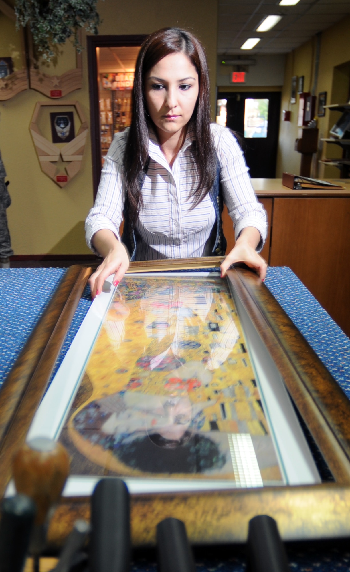 Deniz Yara, Arts and Crafts Center’s framing specialist, frames a painting for a customer at the ACC Tuesday, Nov. 3, 2009 at Incirlik Air Base, Turkey. The framing specialist can teach customers how to frame, frame for them, or even build custom frames. They also offer shadowboxes and retirement gifts inside the shop. (U.S. Air Force photo/Senior Airman Sara Csurilla)