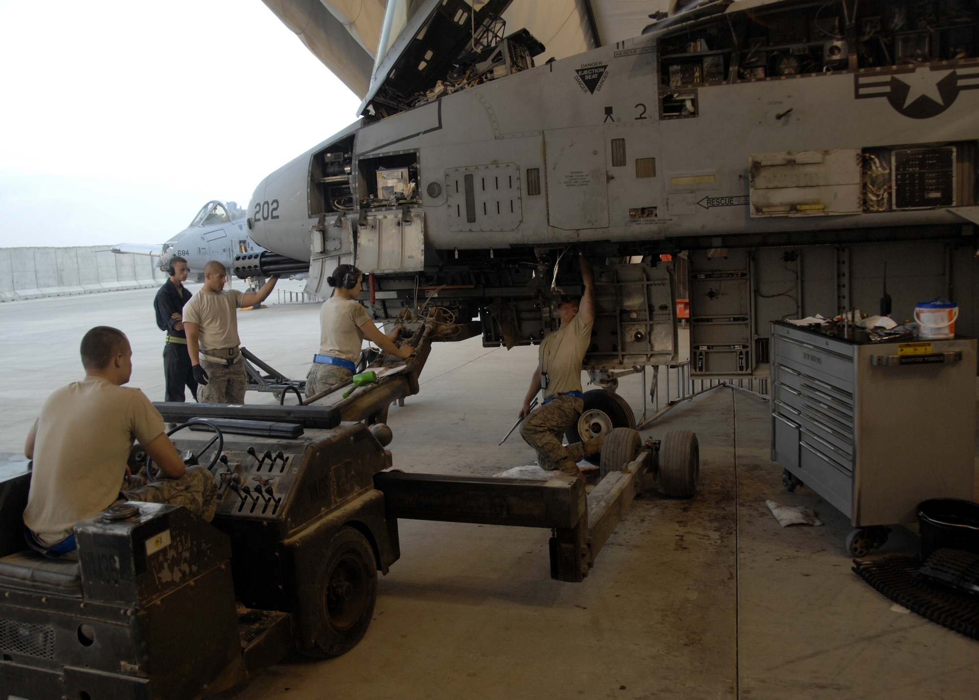 KANDAHAR AIRFIELD, Afghanistan - Airmen from the 451st Expeditionary Aircraft Maintenance Squadron install a 30 mm GAU-8/A seven-barrel Gatling gun here, Nov. 4, 2009. The GAU-8 itself weighs 620 pounds, but the complete weapon, with feed system and drum, weighs 4,029 pounds with maximum ammunition load. (U.S. Air Force photo/Senior Airman Timothy Taylor)