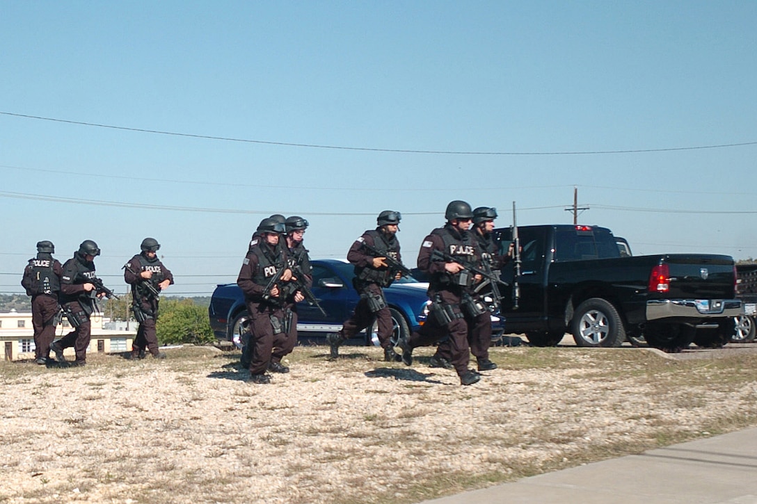 SWAT team members approach a building with a gunman inside.  Thirteen people were killed and 30 more wounded in an attack by a lone gunman at Fort Hood Nov. 5, 2009.