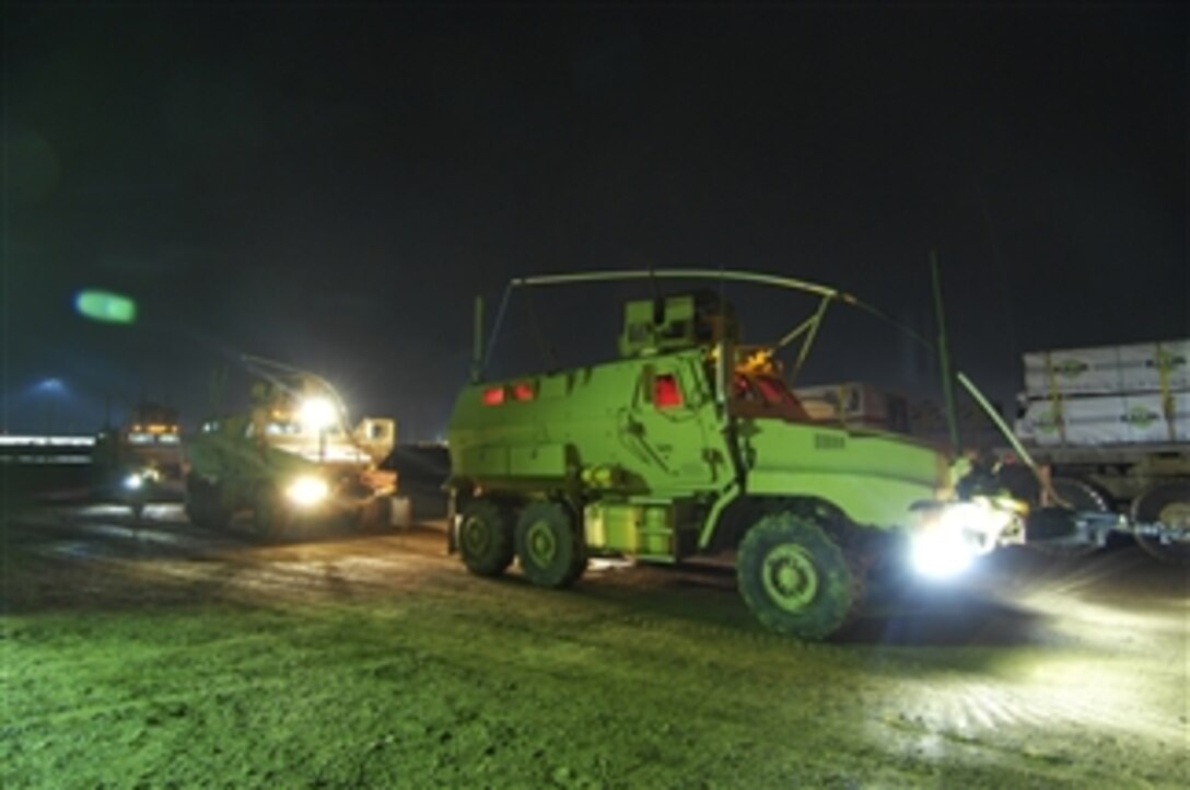 Mine resistant, armor protected vehicles from Delta Company, 1st Battalion, 28th Infantry Regiment, 4th Infantry Brigade Combat Team, 1st Infantry Division stand ready to escort supply trucks leaving Albakir Air Field in Balad, Iraq, on Oct. 31, 2009.  