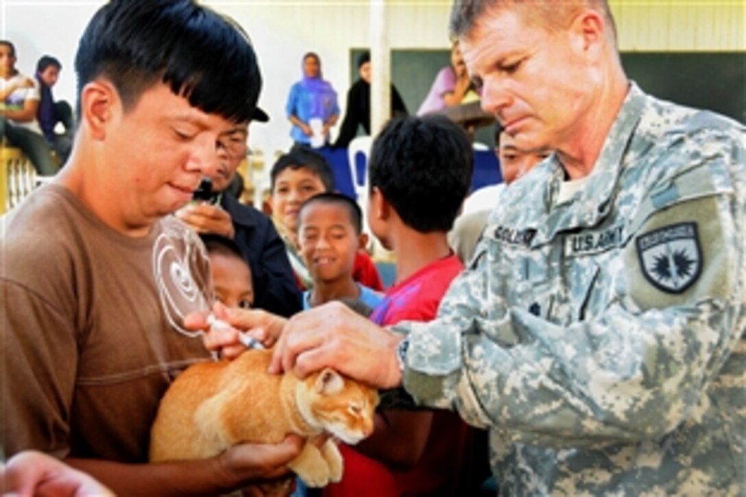 U.S. Army Lt. Col. Steven Goldsmith gives a vitamin treatment to a cat at a veterinarian civil action project  in Lanao Del Sur, Philippines, Nov. 3, 2009. Goldsmith is assigned to Joint Special Operations Task Force Philippines, which partnered with a local veterinarian to educate residents on a variety of topics, including how to give injections and treat sick animals. The vets treated more than 50 animals.