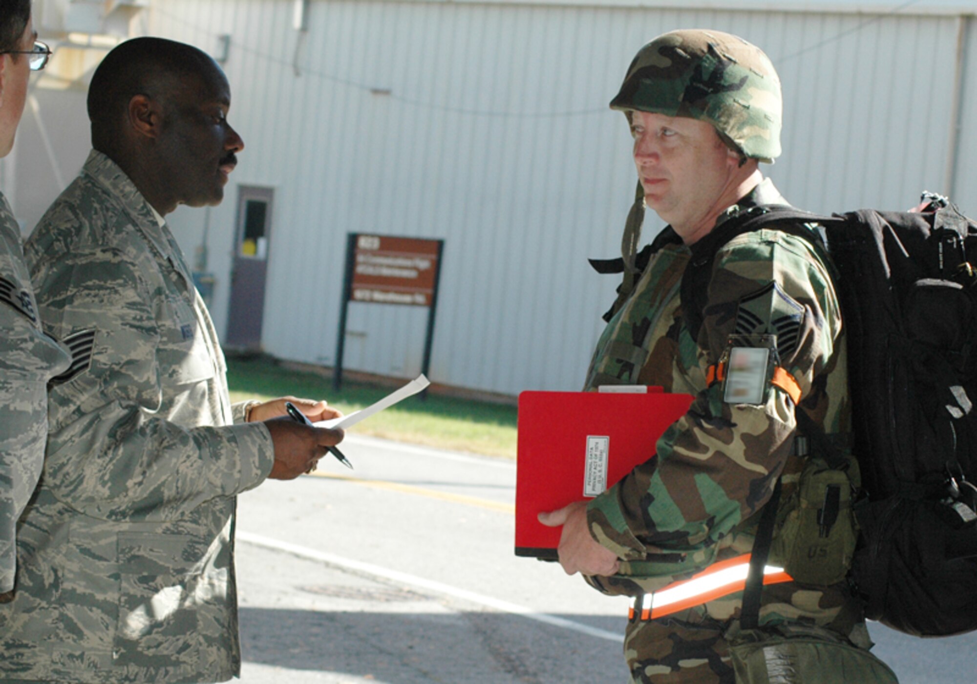 Tech. Sgt. Tharis Ward of the 94th Mission Support Squadron checks the credentials of a deploying Airman at the processing center entrance during an Operational Readiness Exercise at Dobbins Air Reserve Base Nov. 7. The ORE is in preparation for an Operational Readiness Inspection scheduled for Dec. The exercise simulated a short-notice deployment and demonstrated the importance of traditional reservists being fully qualified to deploy anywhere in the world at any given time. (U.S. Air Force photo/Tech. Sgt. James Branch)