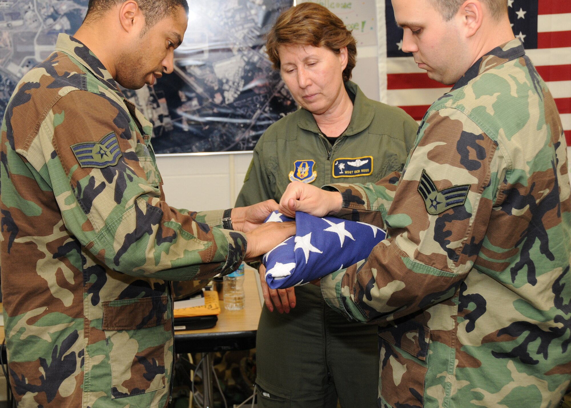 Master Sgt. Deb Ross, 94th Civil Engineering Squadron first sergeant, ensures that Staff Sgt. Tony Hylton and Senior Airman Chris Galkgos demonstrate the correct flag folding technique in preparation for the retreat ceremony during the November unit training ceremony.  

The opportunity to perform the retreat ceremony is shared by each unit within the 94th Airlift Wing at Dobbins Air Reserve Base.  (U.S. Air Force photo/Tech. Sgt. Nicholas B. Ontiveros)
