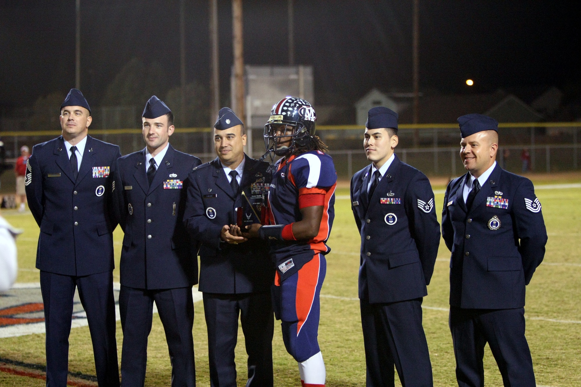 Lt. Col. Ruslan Sanchez (center), 364th Recruiting Squadron commander, and members of his squadron, present Isaiah Burse, Modesto Christian High School quarterback, with a trophy recognizing him as the Air Force's National Football Player of the Week, Oct. 9. (Photo courtesy Scott Fahlgren)