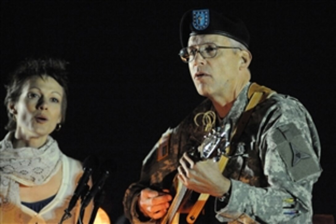 Army Chaplain (Col.) Mike Lembke, III Corps, plays guitar, leading mourners in song during a candlelight vigil Nov. 6, 2009, to commemorate soldiers and civilians killed and wounded Nov. 5, 2009, by a lone gunman inside and near the Soldier Readiness Processing Center at Fort Hood, Texas.