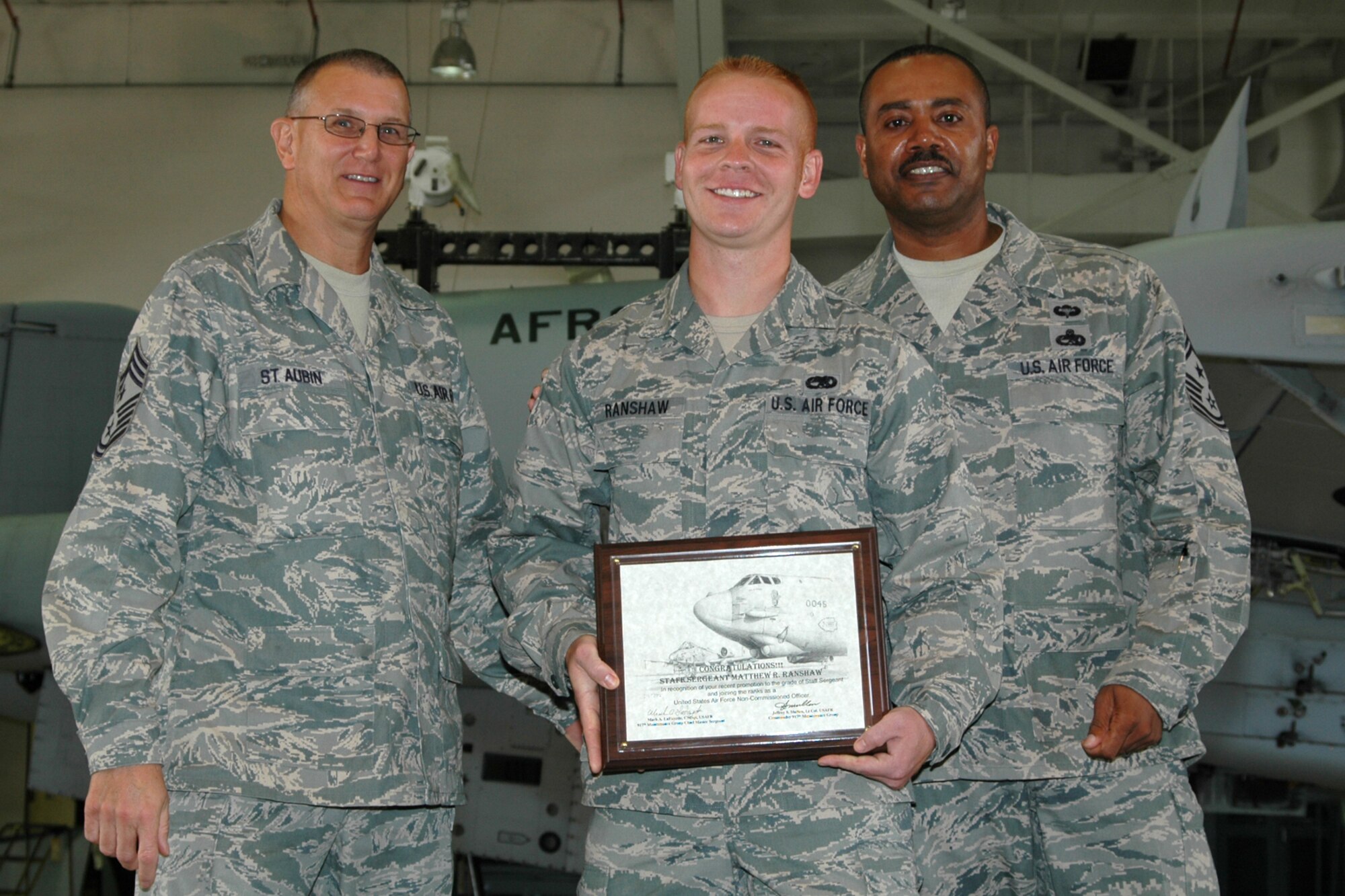Staff Sgt. Matthew Ranshaw, munitions systems mechanic, 917th Maintenance Group, a newly promoted Non-commissioned Officer, smiles as he accepts his certificate during the group’s NCO induction ceremony at Barksdale Air Force Base, La., November 7, 2009.  Presenting the certificate were Chief Master Sgt. Lesley Morrissette, 10th Air Force, command chief and Chief Master Sgt. Keith St. Aubin, 917th Wing, command chief.  Twenty-one staff sergeants were recognized for their promotions. (U.S. Air Force photo/Senior Airman Crystal Jordan)