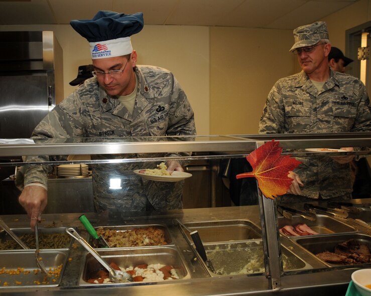 Major Shawn Streck and Chief Master Sergeant Dave Miller, 185th Air Refueling Wing, Sioux City Iowa, serve up a special holiday meal for the troops.   