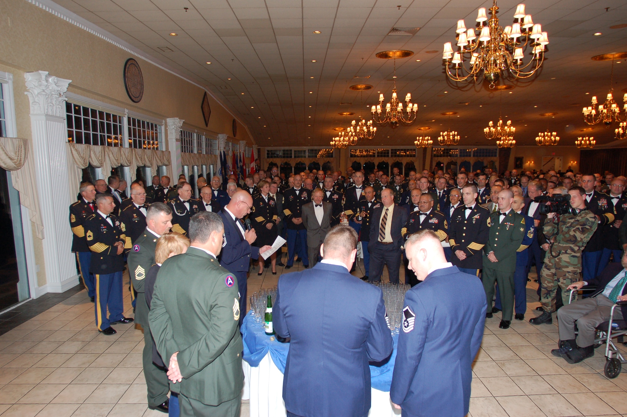 A large group of Army and Air Force Senior Non-Commissioned Officers from the Conn. National Guard gather with retirees and other guests around the “grog bowl” as part of a symbolic ceremony during the Senior NCO Dining-In Oct. 1, 2009, at the Aqua Turf Club in Plantsville, Conn.  Members of the Air National Guard turned out in big numbers for the event, doubling their attendance figure from the year prior.  The event raised almost $4000 for the Junior Enlisted Joint Combat Dining-In Fund.  (U.S. Air Force Photo by Capt. Jefferson S. Heiland) 