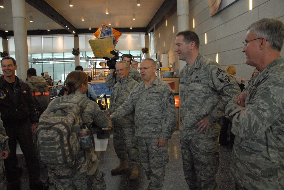 Staff Sgt. Michelle Urso, crew chief, 103rd Maintenance Squadron, shakes the hand of Chief Master Sgt. Francis Macsata as she is welcomed home at Bradley International Airport, Windsor Locks, Conn., October 4, 2009, after being deployed to Southwest Asia.  Urso served as a crew chief with the 379th Expeditionary  Squadron supporting the C-21 mission of providing quick airlift capabilities for personnel and equipment throughout the U.S. Central Command area of responsibility.  (U.S. Air Force Photo by Staff Sgt. Teddy Andrews)