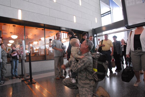 Staff Sgt. Douglas Henry, jet engine mechanic, 103rd Maintenance Squadron, enjoys a hug from his grandson, Chase Lacasse, 1, at the Bradley International Airport terminal, Windsor Locks, Conn. Oct. 4, 2009.  Henry returned home after deploying to Southwest Asia in support of overseas contingency operations.  (U.S. Air Force Photo by Staff Sgt. Teddy Andrews)