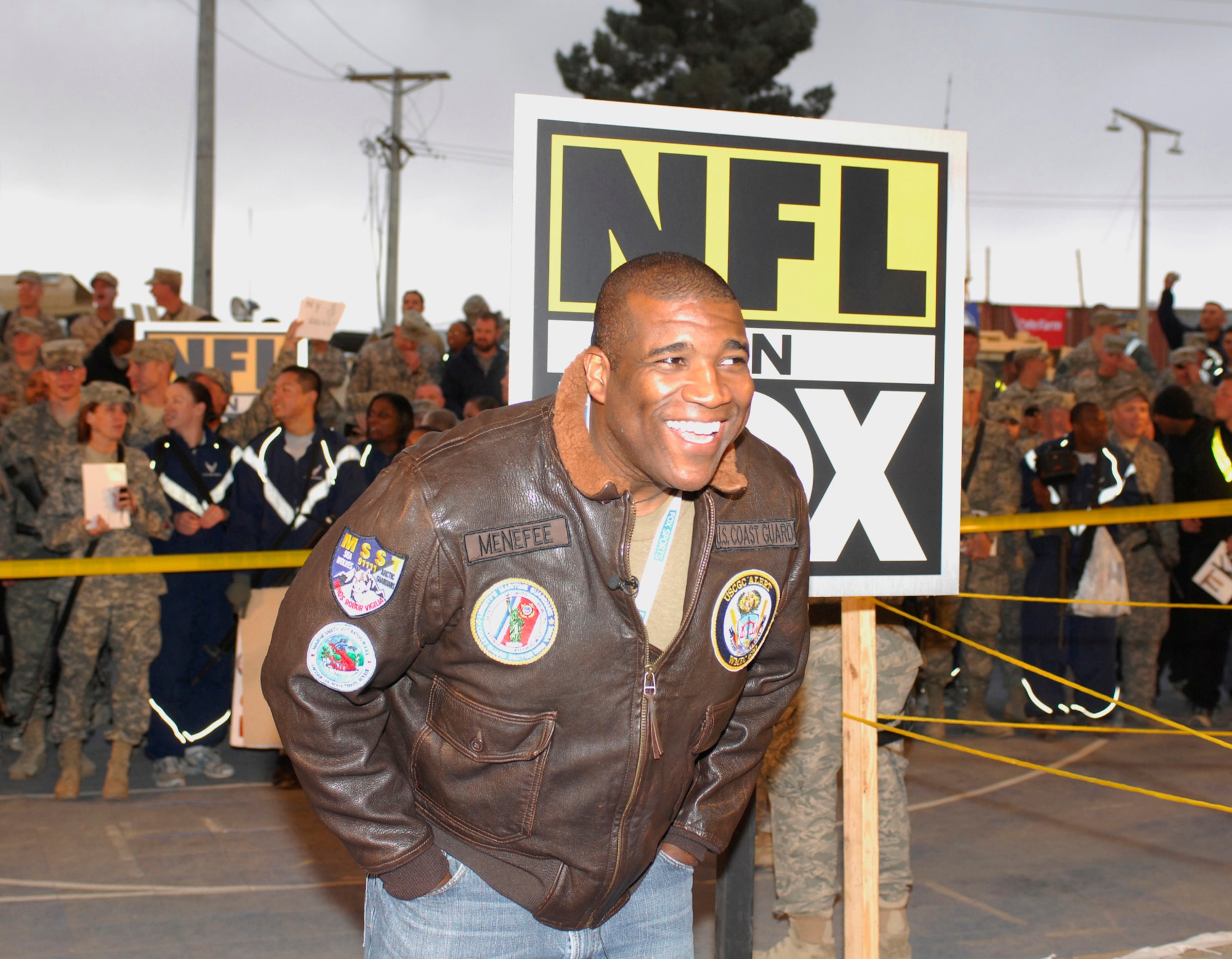 BAGRAM AIRFIELD, Afghanistan -- Curt Menefee, FOX NFL Sunday, stops for a quick question from a fan in a crowd of Airmen, Soldiers, Sailors and Marines. "Our men and women in the military put themselves in harm's way to protect everything we hold dear, and none more so than those who are stationed in the Middle East," FOX Sports Chairman David Hill said. "It is our privilege and honor to take FOX NFL Sunday to them in November, right before Veterans Day. Amidst the fun and football, it's our hope to showcase the dedication of these men and women who have to defend against a lot more than the wildcat."( U.S. Air Force photo/Tech. Sgt.  John Jung)