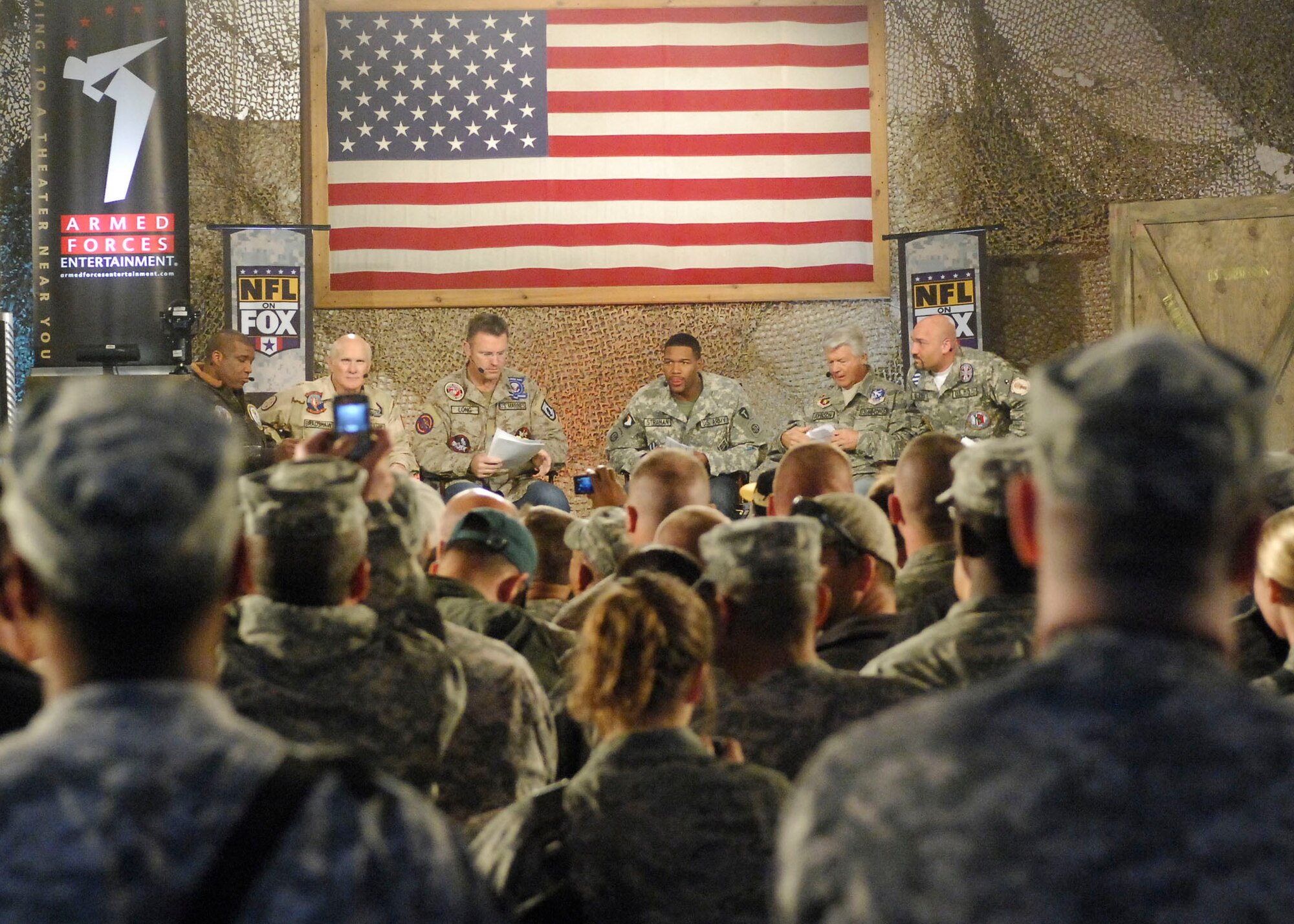 BAGRAM AIR FIELD, Afghanistan -- The crowd snaps photos during the "Fox NFL Sunday" pregame Nov. 7, 2009. (From left to right) Curt Menefee, Terry Bradshaw, Howie Long, Michael Strahan, Jimmy Johnson, and Jay Glazer came to visit Bagram to boost morale.  The "Fox NFL Sunday" team is scheduled to broadcast live Nov. 8, 2009 from here.  (U.S. Air Force photo/Senior Airman Felicia Juenke)