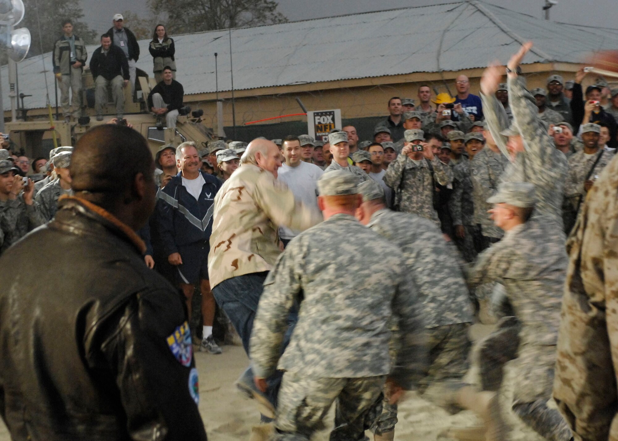 BAGRAM AIR FIELD, Afghanistan -- Soldiers attempt to tackle Terry Bradshaw during a football game with the troops Nov. 7, 2009. Jay Glazer, Terry Bradshaw, Jimmy Johnson, Curt Menefee, Howie Long, and Michael Strahan came to visit Bagram to boost morale.  The "Fox NFL Sunday" team is scheduled to broadcast live Nov. 8, 2009 from here.  (U.S. Air Force photo/Senior Airman Felicia Juenke)
