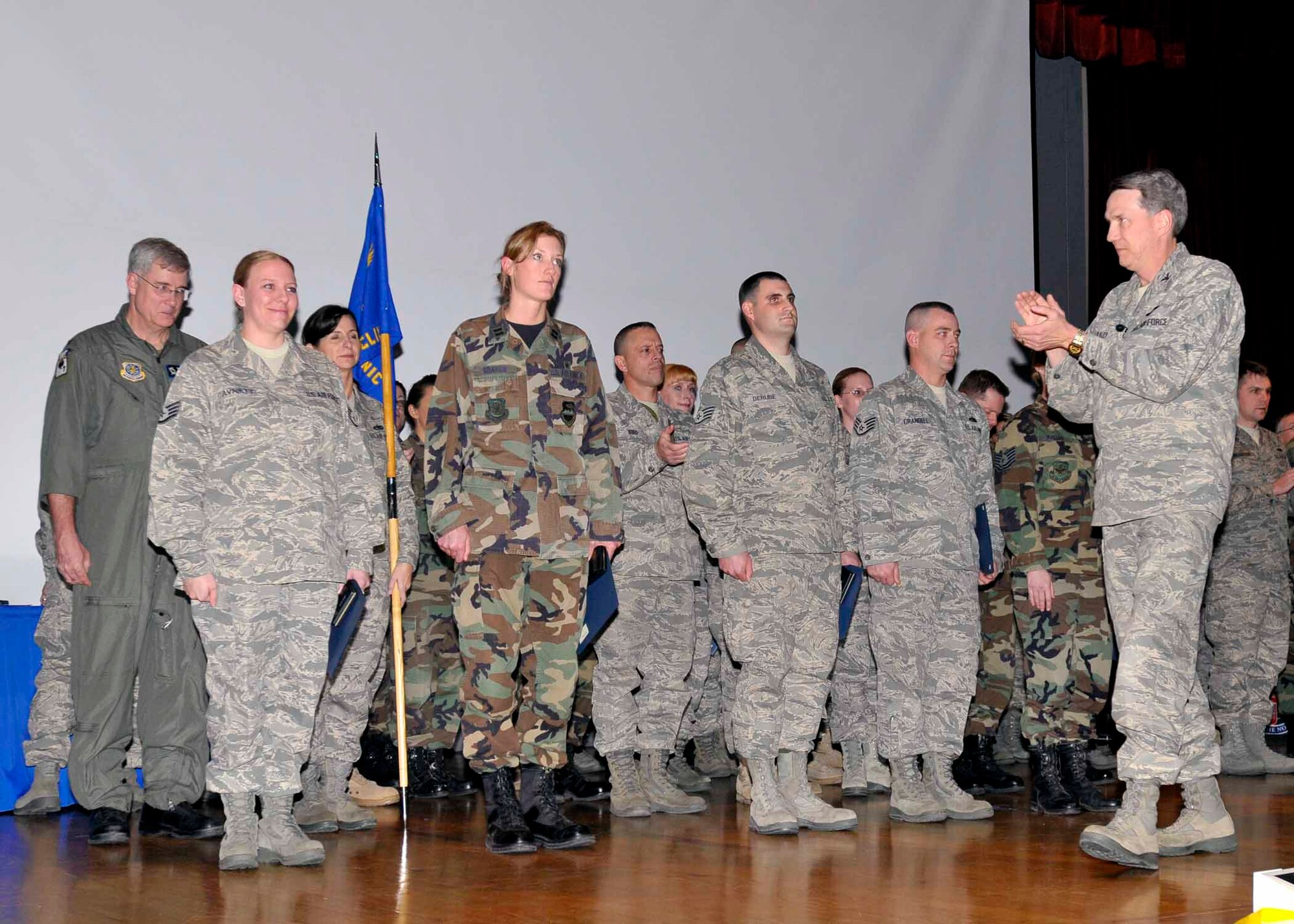 Col. Greg Bulkley, 141st Air Refueling Wing commander, applauds the 141st Medical Group after presenting them with an Air Force Outstanding Unit Award during the 141st ARW Commander’s Call, Fairchild AFB, Wash., Nov. 7, 2009. (U.S. Air Force photo by Staff Sgt. Anthony Ennamorato/Released)