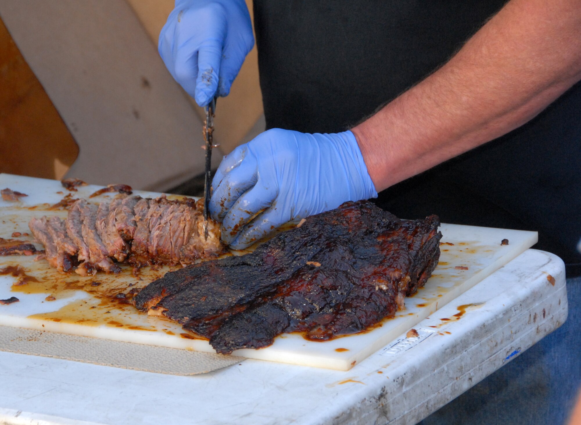 Dean Green cuts barbecued beef brisket for Air Force Reservists from the 442nd Fighter Wing Nov. 7, 2009, at Whiteman Air Force Base, Mo.  Mr. Green is part of a group of volunteers from Fishnet Security, INC., who volunteer their time and barbecue talents to prepare feasts for American service personnel.  The group has been cooking for more than four years to say "thank you" to military members for their sacrifices and service.  Fishnet Security is a private company based in Kansas City.  The group has cooked barbecue for the Citizen Airmen of the 442nd FW in the past as a way to show appreciation for the wing's contribution to national defense.  (U.S. Air Force photo/Staff Sgt. Kent Kagarise)  