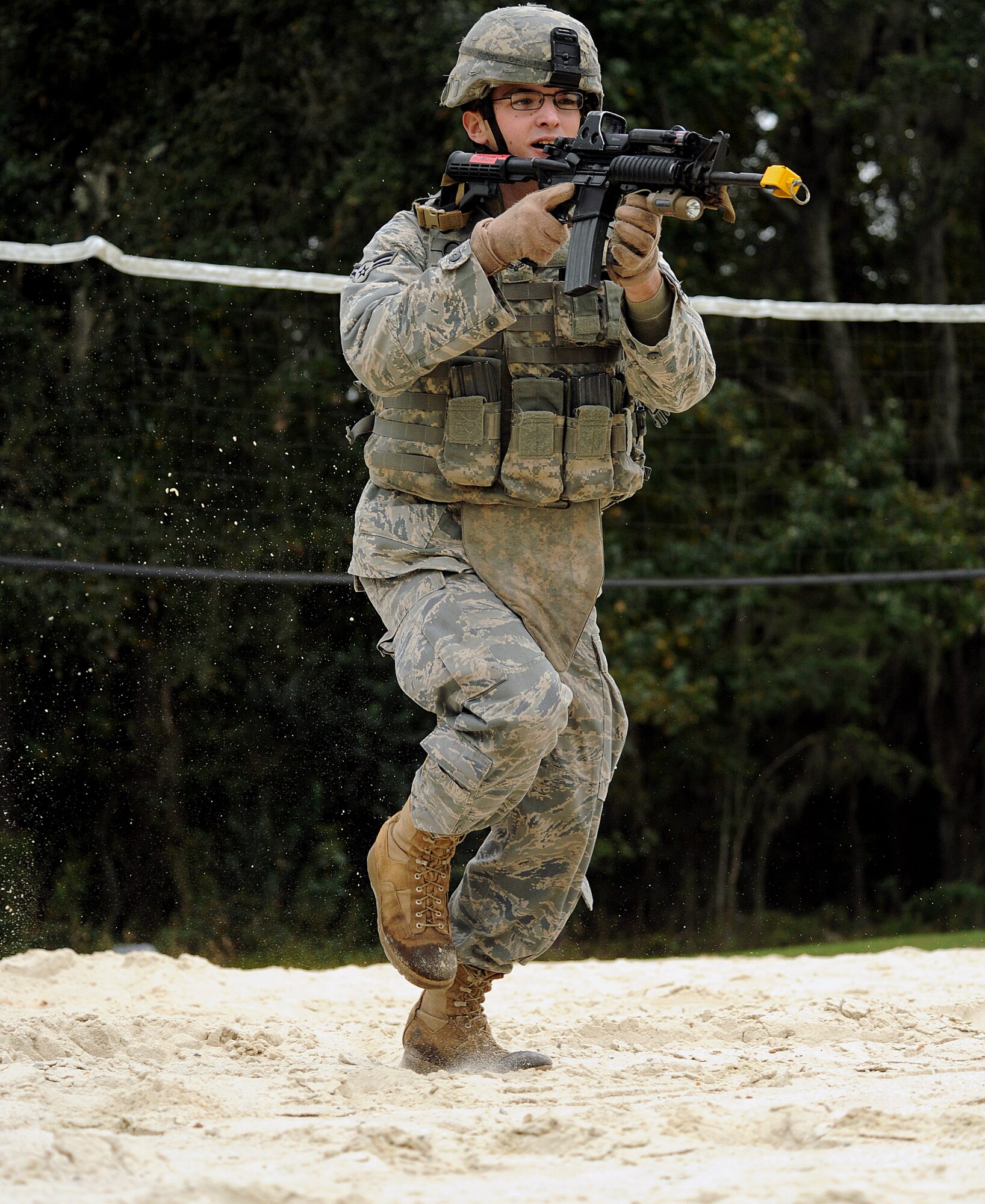 MOODY AIR FORCE BASE, Ga. -- Airmen 1st Class Joshua Hudson, 823rd Security Forces Squadron specialist, runs through an abandoned volleyball sand pit during combat maneuvers training here Nov. 2. Airmen were tasked to provide cover and suppressive fire to help their team member move to a safe position. (U.S. Air Force photo by Airman 1st Class Joshua Green) 
